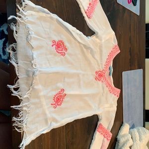 Girls white beach coverup with pink detailing.